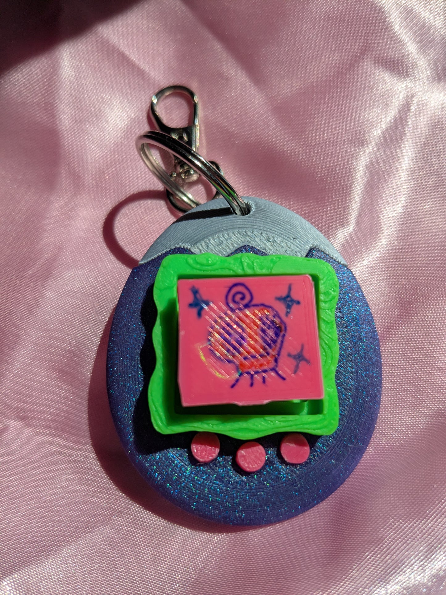 Colorful keychain with a cartoon design on a pink fabric background