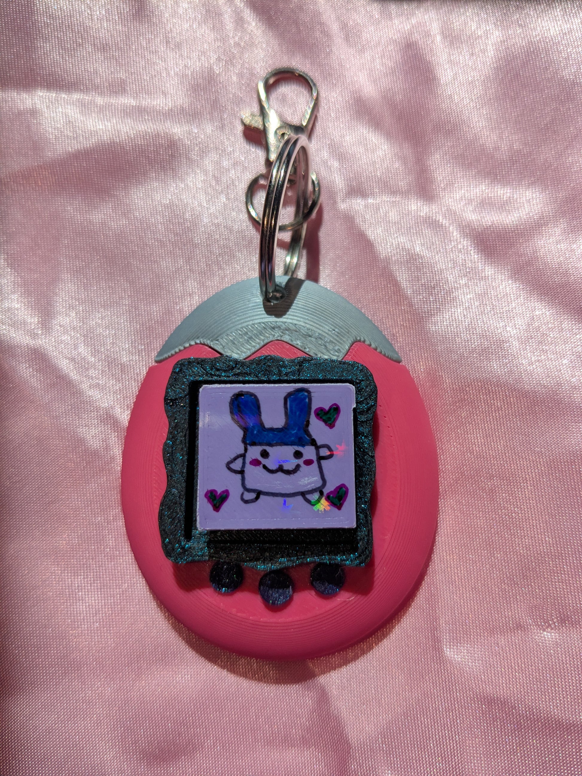 Keychain with cartoon character on a pink fabric background