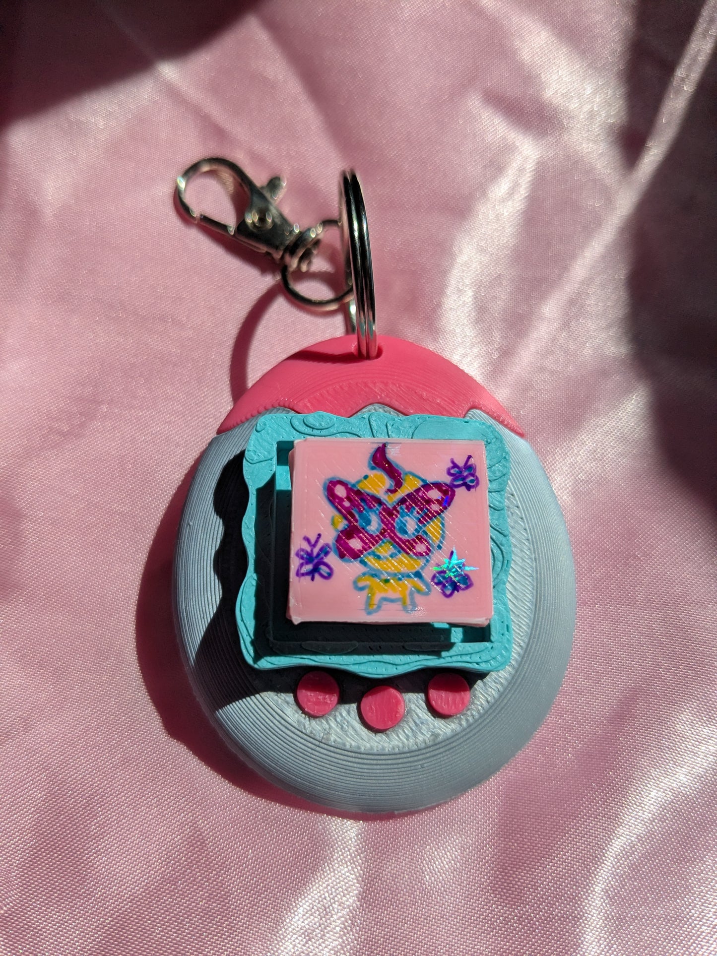 Keychain with colorful design on a pink fabric background